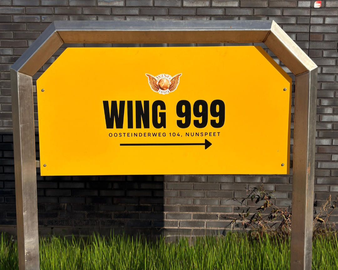 Collection of Yellow sign with 'WING 999' text and logo against a brick wall. in a gallery layout